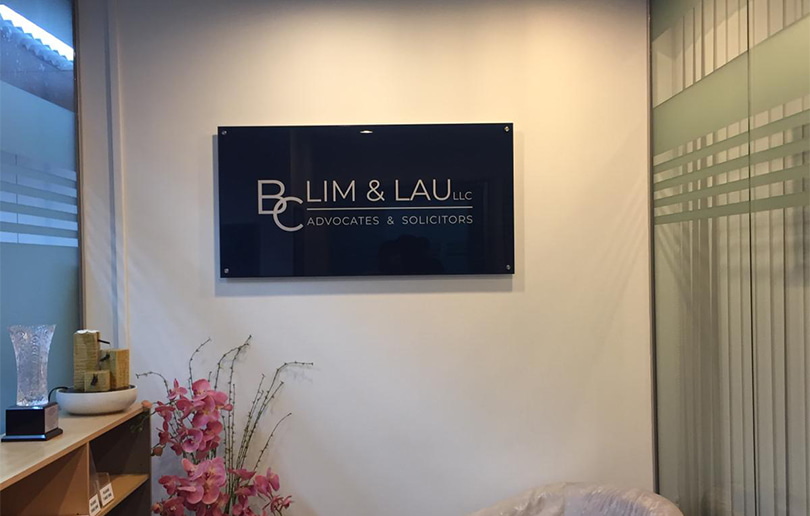 Dark blue acrylic office sign displaying law firm branding in a professional reception environment.
