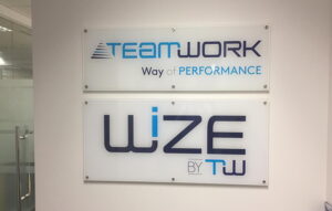 Corporate acrylic wall signage displaying company branding with layered acrylic panels and standoff mounting.