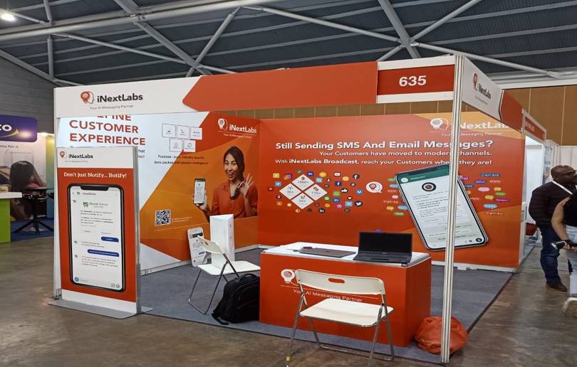 Custom exhibition booth with iNextLabs branding, large-format graphics, wall panels, and promotional messaging at a Singapore trade show.